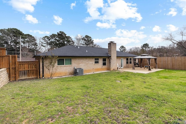 back of property featuring a patio, a yard, central AC, a gazebo, and brick siding