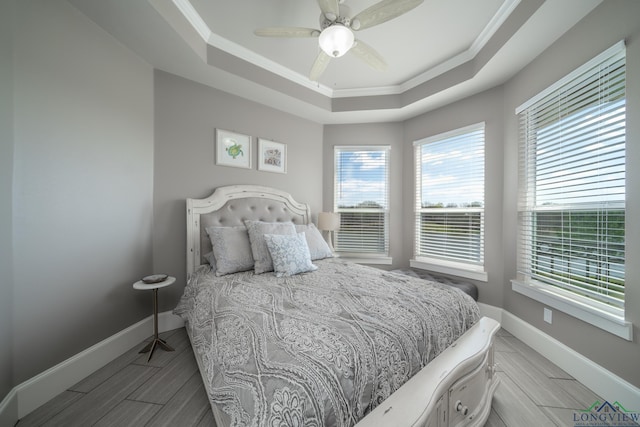 bedroom featuring a tray ceiling, ceiling fan, and crown molding