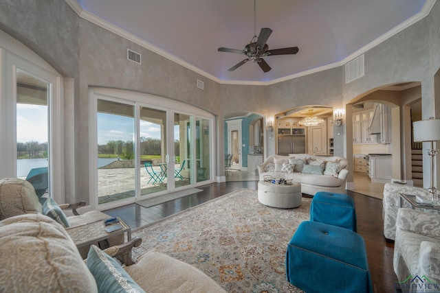 living room featuring a water view, dark hardwood / wood-style floors, crown molding, and ceiling fan