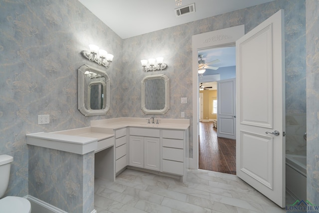 bathroom featuring vanity, ceiling fan, toilet, and a bath