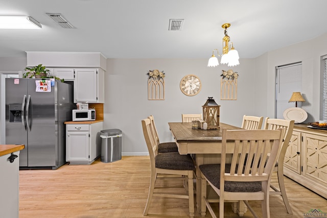 dining room featuring a chandelier and light wood-type flooring