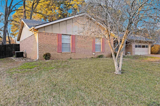 view of front facade with a garage, central AC unit, and a front lawn