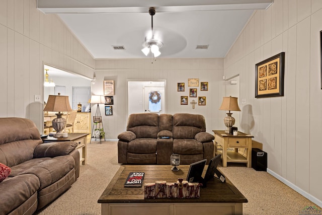 carpeted living room featuring ceiling fan, ornamental molding, and beam ceiling