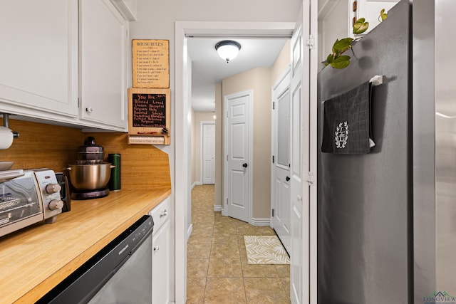 kitchen featuring white cabinetry, light tile patterned floors, decorative backsplash, and dishwasher