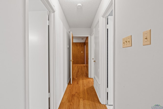 hallway featuring a textured ceiling and light wood-style flooring