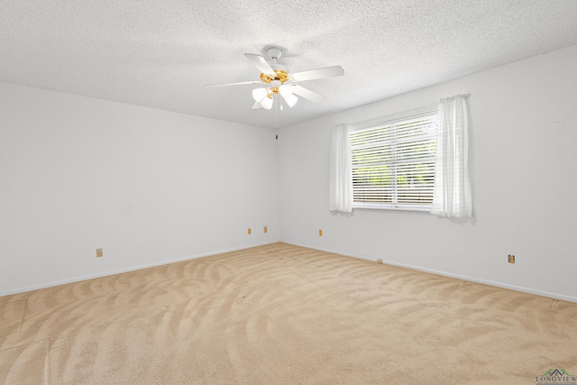 unfurnished room with a textured ceiling, carpet flooring, baseboards, and a ceiling fan