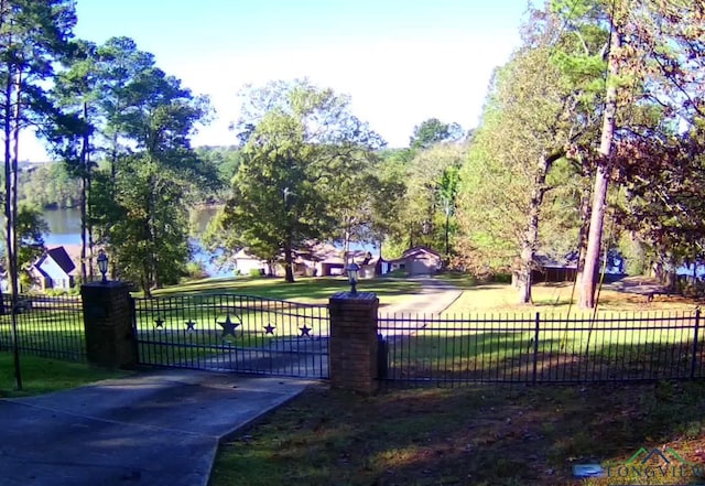 view of gate featuring a yard and a water view