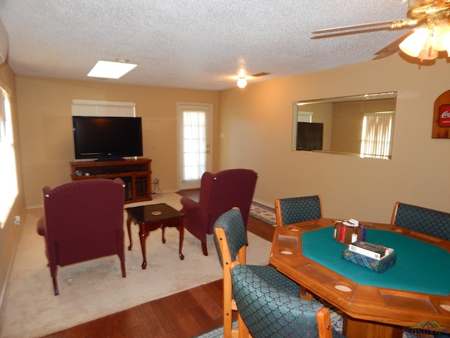 dining area with ceiling fan, wood-type flooring, and a textured ceiling