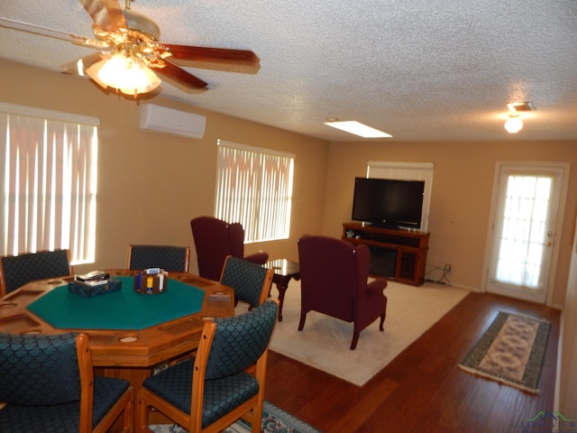 dining space featuring a wall mounted air conditioner, ceiling fan, hardwood / wood-style floors, and a textured ceiling