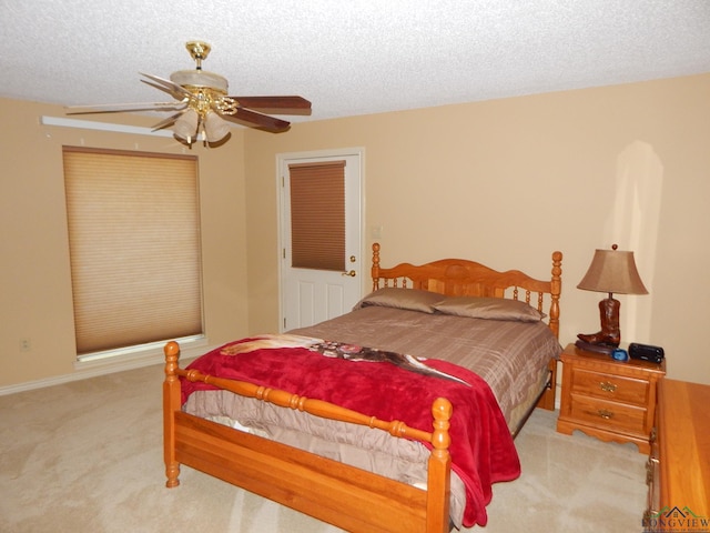 carpeted bedroom with a textured ceiling and ceiling fan