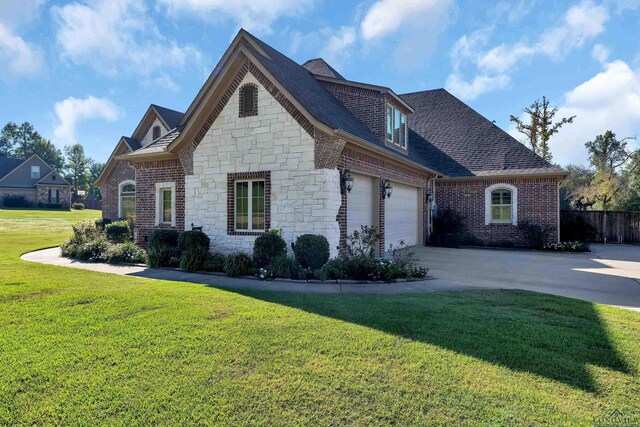 view of front of home with a garage and a front lawn