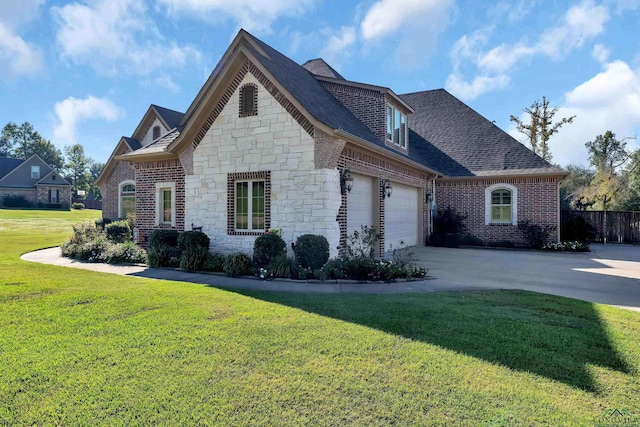 french country inspired facade with a front lawn, concrete driveway, brick siding, and an attached garage