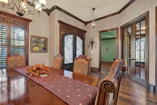 dining space featuring french doors, a notable chandelier, ornamental molding, dark wood-type flooring, and baseboards