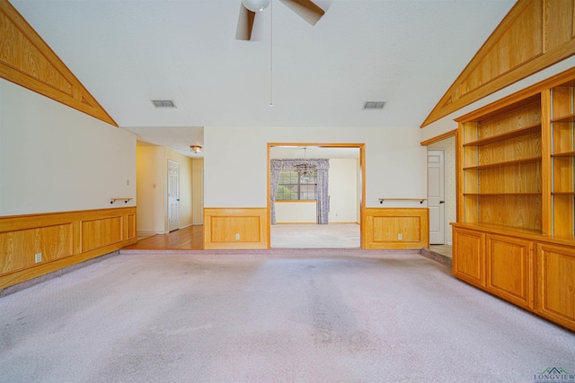 3714 Bill Owens Pkwy, Longview, TX 75605 - unfurnished living room with light carpet, lofted ceiling, a wainscoted wall, and ceiling fan