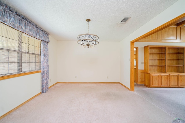 3714 Bill Owens Pkwy, Longview, TX 75605 - empty room with a chandelier, light carpet, a textured ceiling, and baseboards