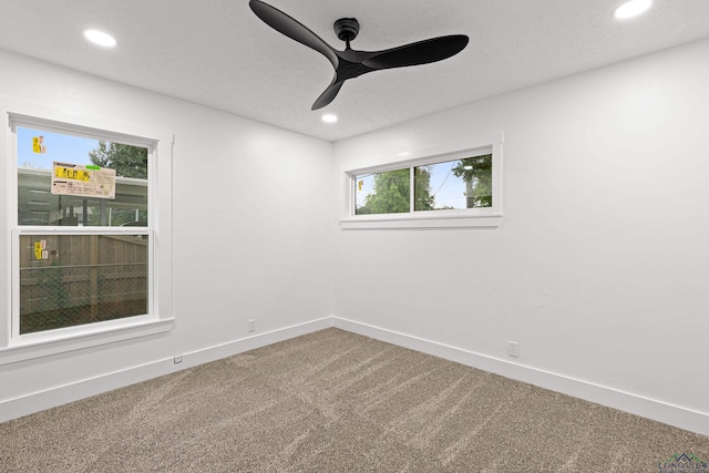 carpeted spare room featuring ceiling fan