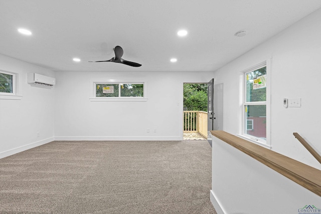 carpeted empty room with an AC wall unit and ceiling fan