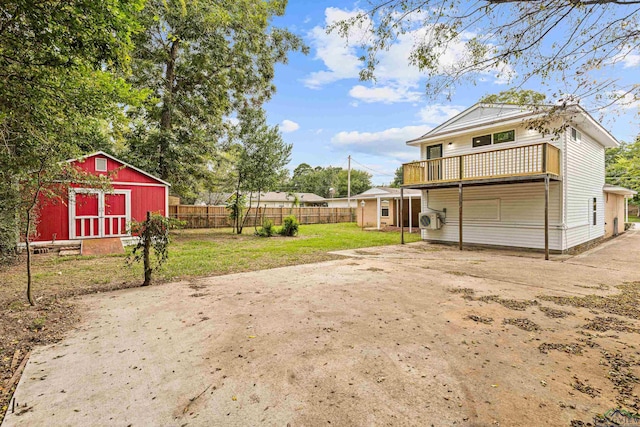 view of yard featuring a balcony and a storage unit