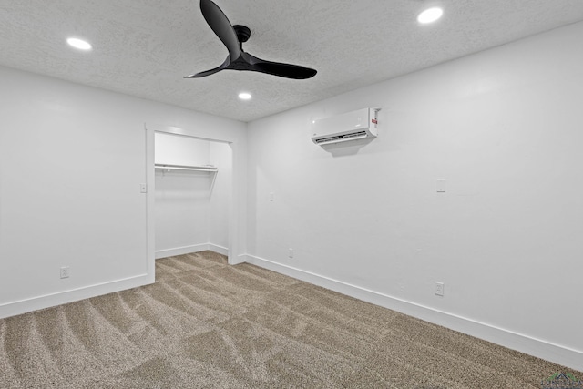 carpeted empty room with ceiling fan, an AC wall unit, and a textured ceiling