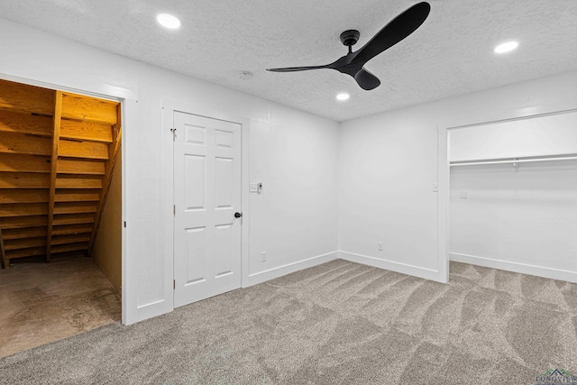 unfurnished bedroom with carpet, ceiling fan, and a textured ceiling