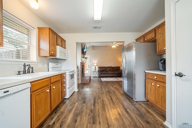 1610 Amanda Ln, Kilgore, TX 75662 - kitchen with white appliances, dark wood-style flooring, brown cabinets, and light countertops