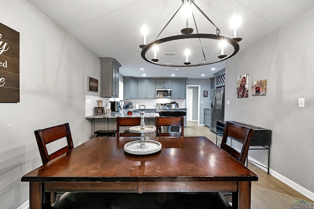 dining room with recessed lighting, visible vents, baseboards, light wood finished floors, and an inviting chandelier