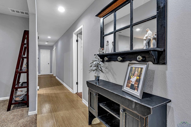 hall featuring recessed lighting, visible vents, baseboards, and wood finished floors