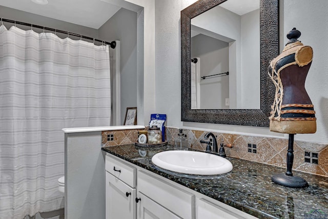 bathroom featuring toilet, vanity, and a shower with curtain