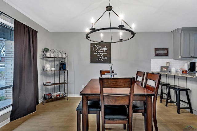 dining space featuring light wood-style flooring and baseboards