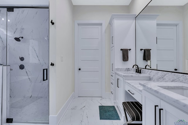 full bath featuring marble finish floor, baseboards, double vanity, and a marble finish shower