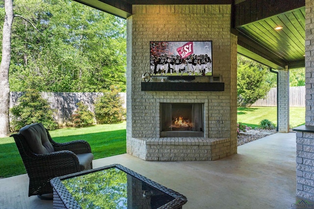 view of patio featuring fence and an outdoor brick fireplace