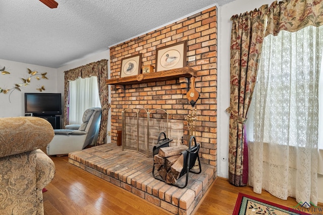 6940 Fm 778, Hawkins, TX 75765 - living area featuring wood finished floors, a brick fireplace, and a textured ceiling