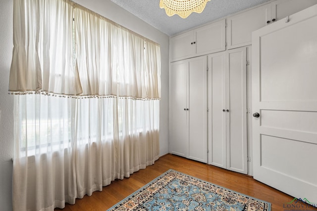 6940 Fm 778, Hawkins, TX 75765 - bedroom with light wood-style floors, a textured ceiling, and a closet
