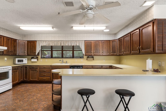 6940 Fm 778, Hawkins, TX 75765 - kitchen featuring white appliances, a textured ceiling, light countertops, a peninsula, and a sink