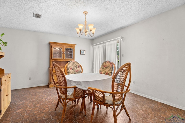 6940 Fm 778, Hawkins, TX 75765 - dining room with a chandelier, a textured ceiling, stone finish floors, and baseboards