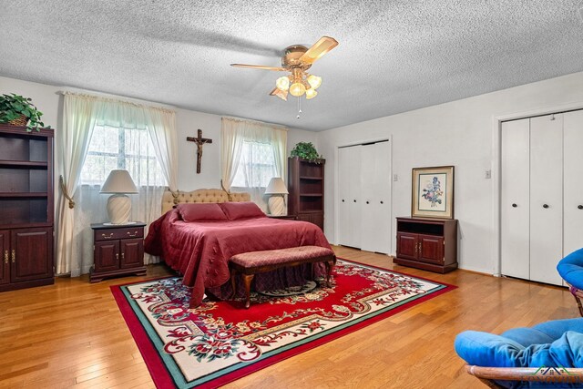 6940 Fm 778, Hawkins, TX 75765 - bedroom with two closets, a textured ceiling, light wood-style floors, and a ceiling fan