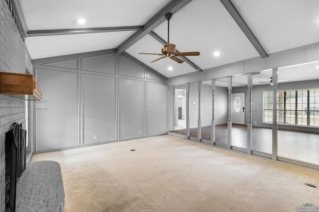 unfurnished living room with a decorative wall, a brick fireplace, a ceiling fan, and carpet