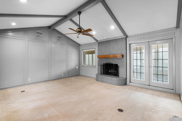 unfurnished living room featuring visible vents, carpet floors, a fireplace, and a decorative wall