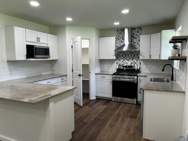 115 Alta St, Longview, TX 75604 - kitchen with stainless steel appliances, wall chimney range hood, a sink, a peninsula, and light stone countertops