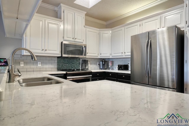 kitchen featuring sink, crown molding, appliances with stainless steel finishes, light stone counters, and white cabinets