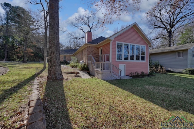 view of side of home with a yard