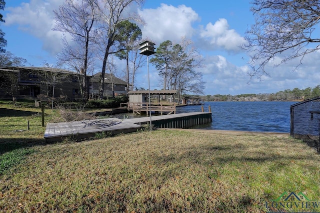 view of dock with a water view and a yard