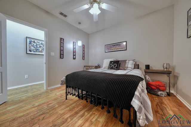 bedroom featuring ceiling fan, a textured ceiling, and light wood-type flooring