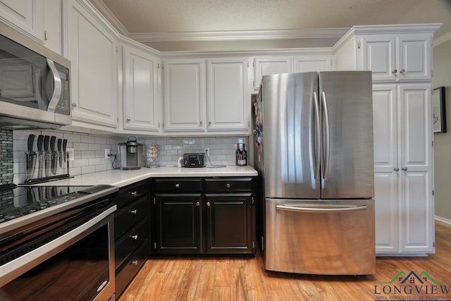 kitchen featuring white cabinetry, ornamental molding, appliances with stainless steel finishes, and decorative backsplash