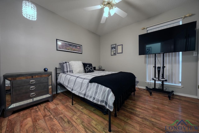 bedroom featuring dark hardwood / wood-style flooring, vaulted ceiling, and ceiling fan