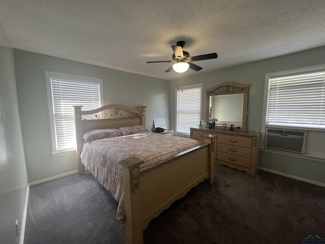 bedroom featuring cooling unit, dark carpet, a textured ceiling, and ceiling fan