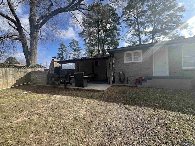 rear view of house featuring a patio and a lawn