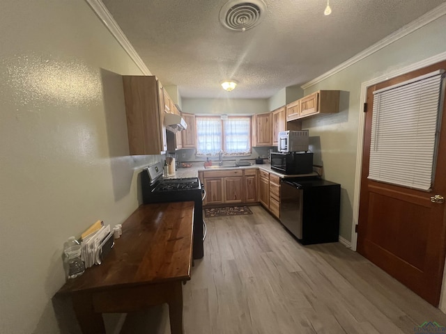 kitchen with gas stove, a textured ceiling, crown molding, and light hardwood / wood-style flooring