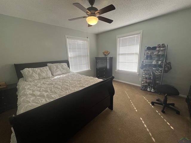 carpeted bedroom featuring ceiling fan and a textured ceiling