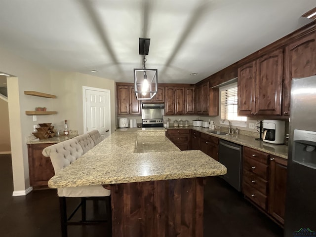 kitchen featuring appliances with stainless steel finishes, sink, a kitchen breakfast bar, light stone counters, and dark brown cabinets